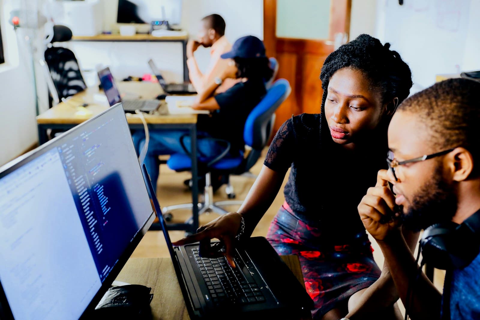 Two engineers reviewing code together on a laptop